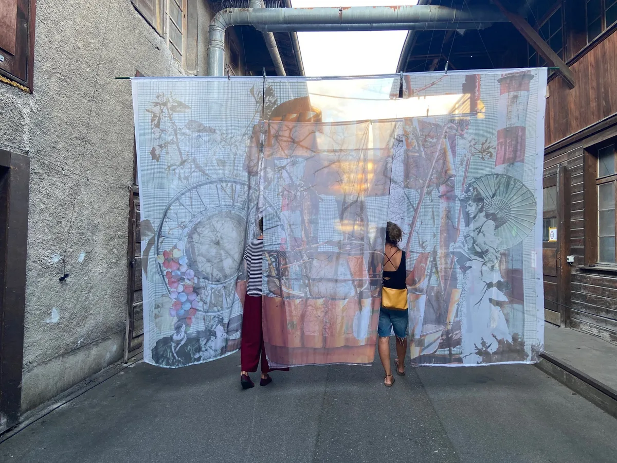 Ein bunter Vorhang als Kunstwerk – und zwei Frauen, die durchschreiten.